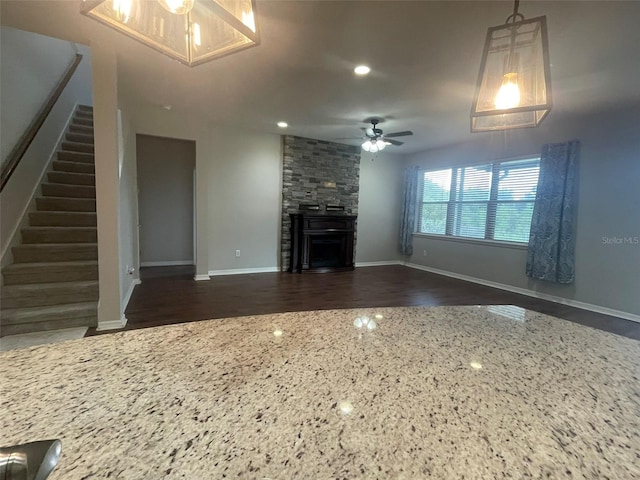 unfurnished living room featuring ceiling fan and a fireplace