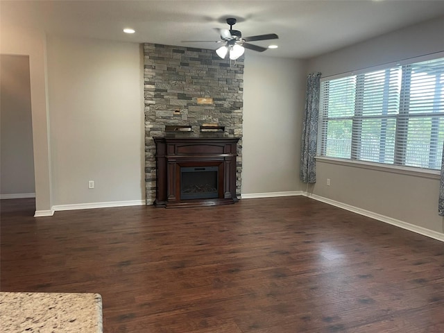 unfurnished living room featuring a fireplace, ceiling fan, and dark hardwood / wood-style floors