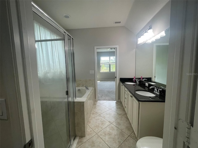 bathroom featuring independent shower and bath, tile patterned flooring, vaulted ceiling, and vanity