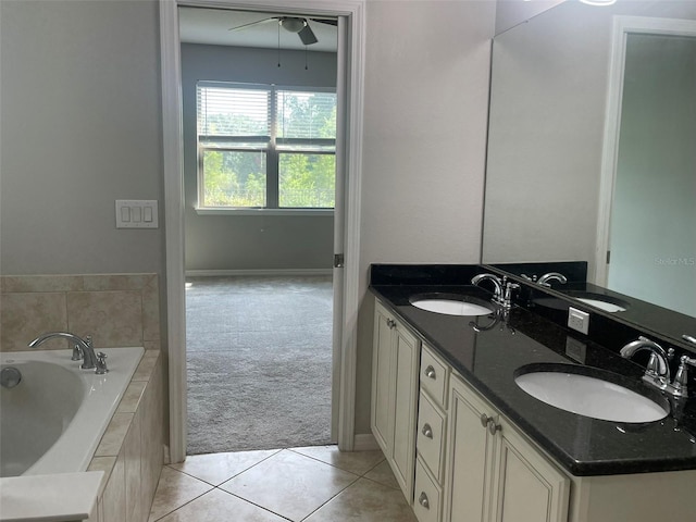 bathroom featuring ceiling fan, tile patterned flooring, vanity, and tiled tub