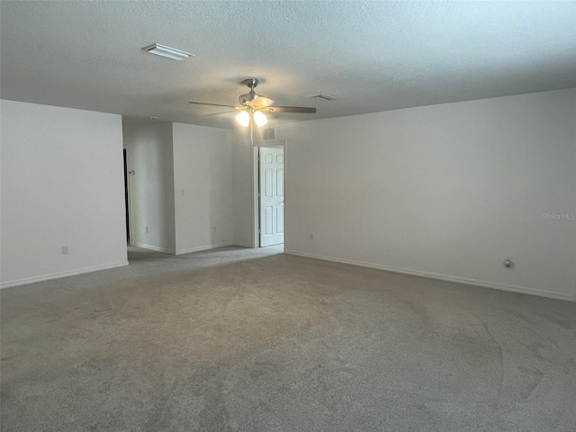 empty room with ceiling fan, carpet floors, and a textured ceiling