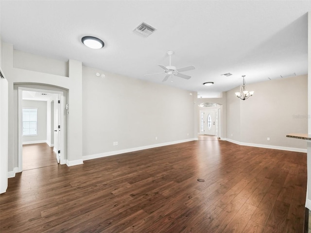 unfurnished living room featuring baseboards, visible vents, dark wood finished floors, and ceiling fan with notable chandelier