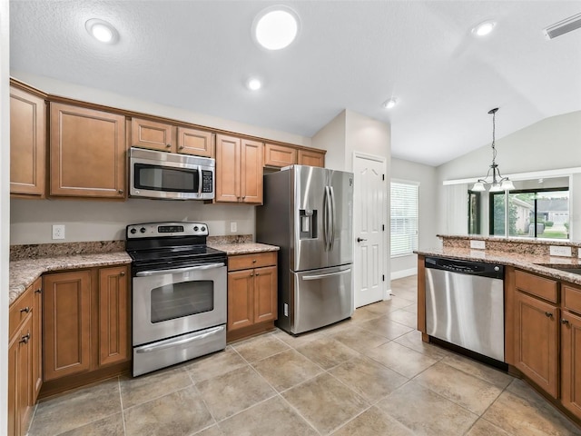 kitchen with brown cabinets, lofted ceiling, visible vents, appliances with stainless steel finishes, and light stone countertops