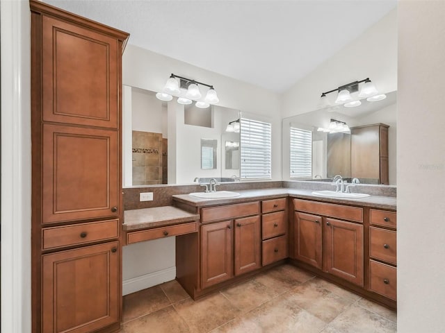 bathroom with lofted ceiling, a sink, and double vanity