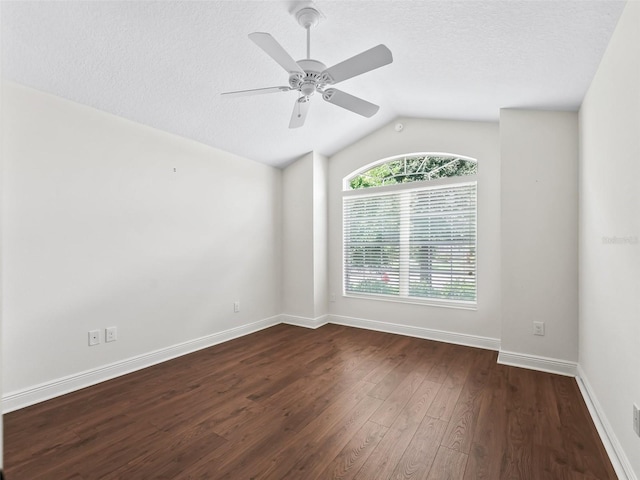 empty room featuring dark wood finished floors, lofted ceiling, ceiling fan, a textured ceiling, and baseboards