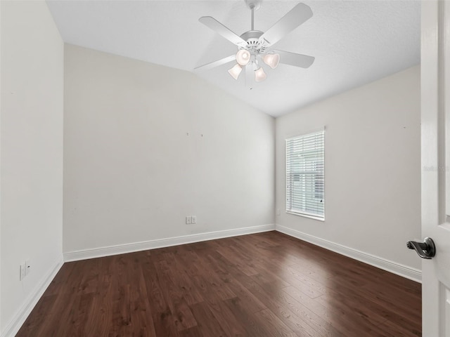 unfurnished room featuring dark wood-type flooring, vaulted ceiling, baseboards, and ceiling fan