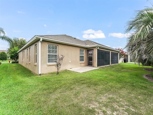 rear view of house with a patio area, a lawn, and stucco siding