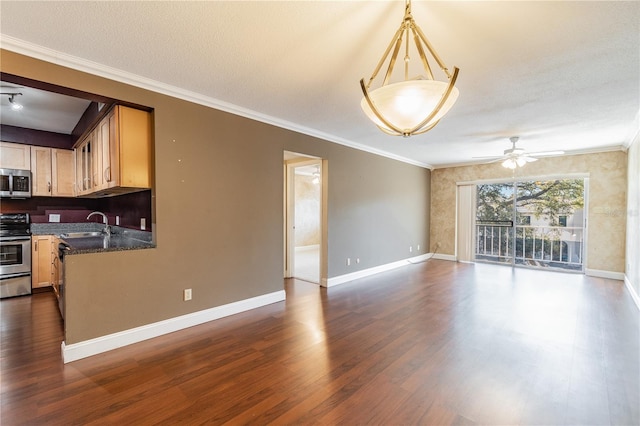 interior space featuring ornamental molding, open floor plan, dark wood finished floors, stainless steel appliances, and ceiling fan