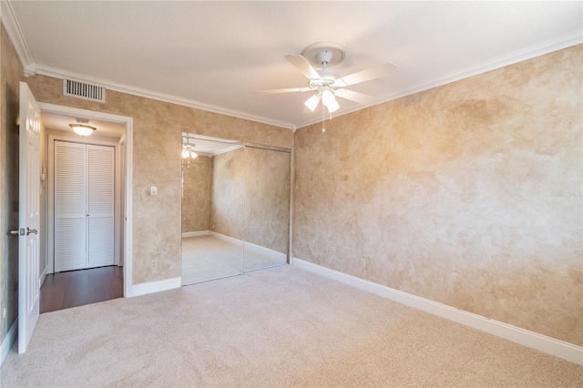 unfurnished bedroom with ceiling fan, crown molding, and light carpet