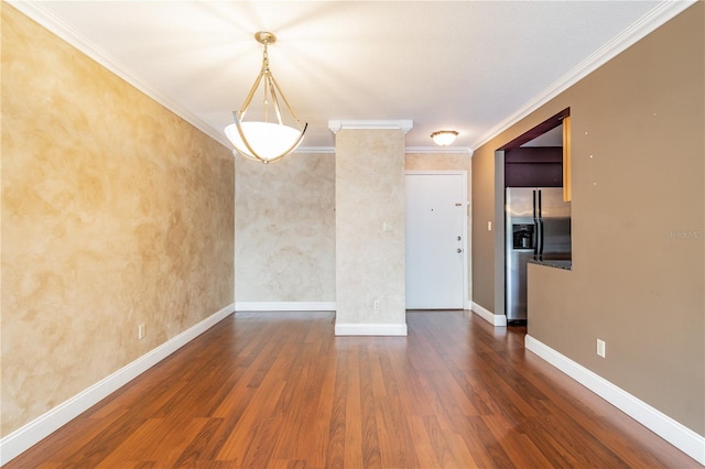 spare room with baseboards, wood finished floors, and ornamental molding