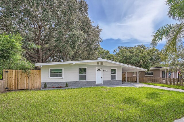 ranch-style home featuring a front yard and a carport