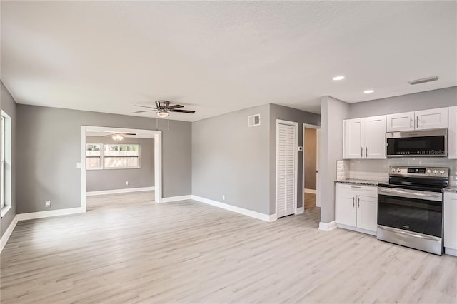 kitchen featuring white cabinets, appliances with stainless steel finishes, light hardwood / wood-style floors, and tasteful backsplash