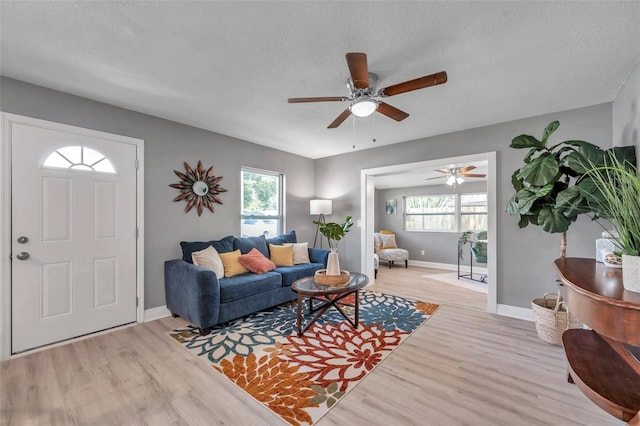 living room with a textured ceiling, light hardwood / wood-style floors, and a healthy amount of sunlight