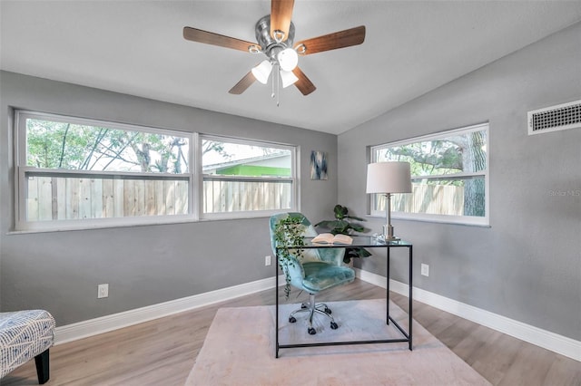 home office featuring plenty of natural light, lofted ceiling, and hardwood / wood-style flooring