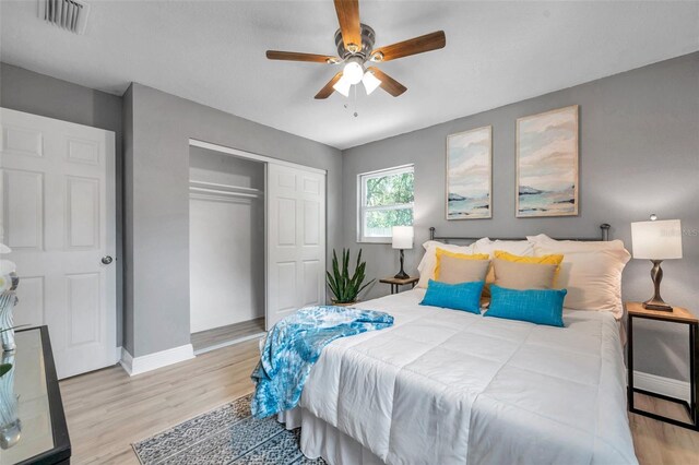 bedroom with ceiling fan, a closet, and light hardwood / wood-style flooring