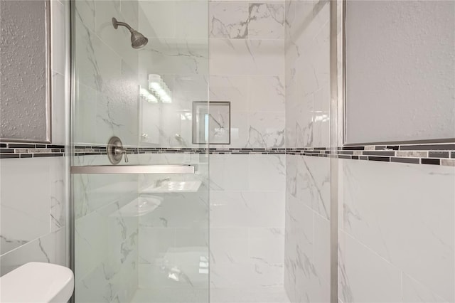 bathroom featuring walk in shower, toilet, and tile walls