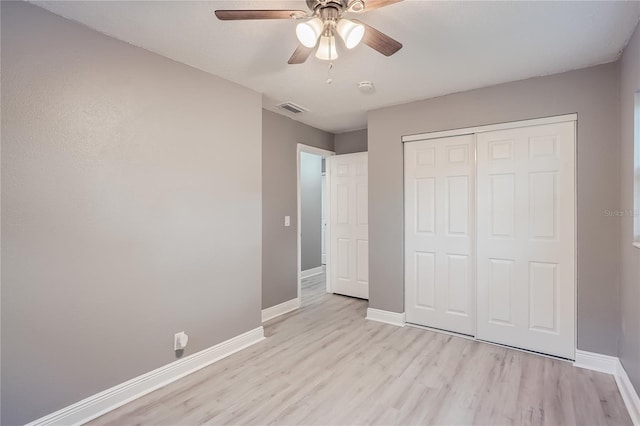 unfurnished bedroom featuring ceiling fan, a closet, and light hardwood / wood-style flooring