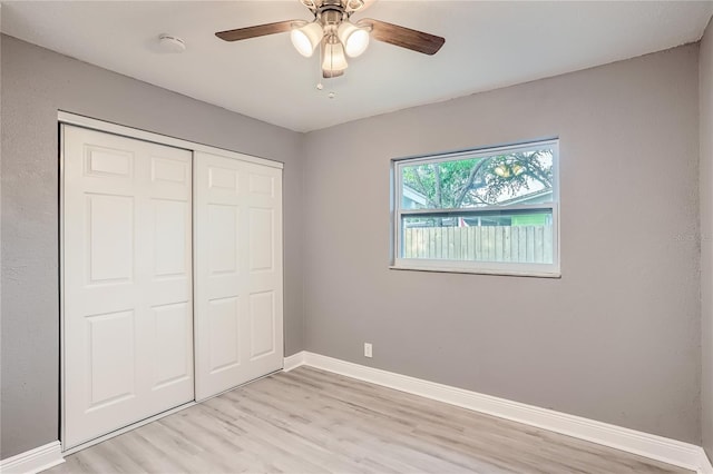 unfurnished bedroom featuring light hardwood / wood-style floors, a closet, and ceiling fan