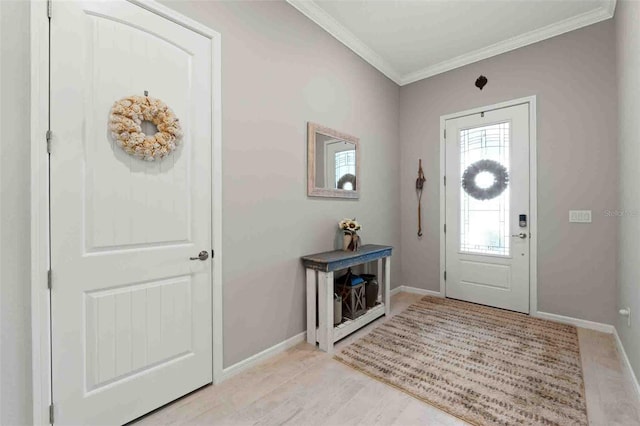 foyer entrance with light hardwood / wood-style floors and ornamental molding