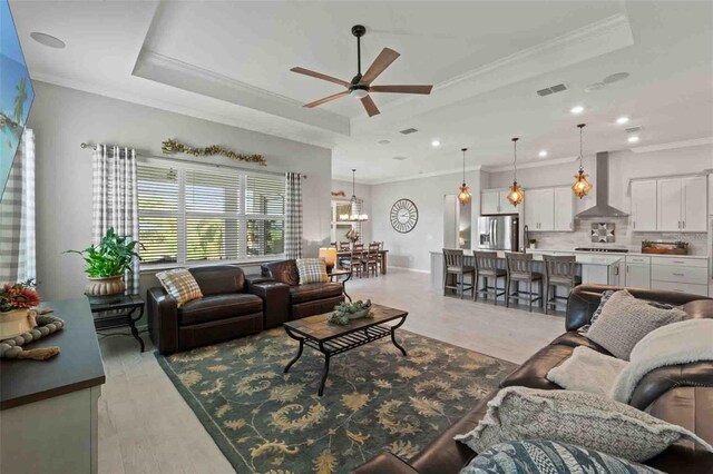 living room featuring a tray ceiling and ornamental molding