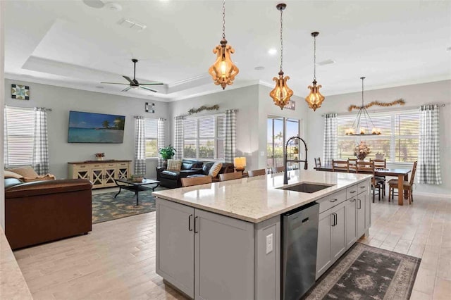 kitchen with sink, stainless steel dishwasher, gray cabinets, light stone countertops, and a kitchen island with sink