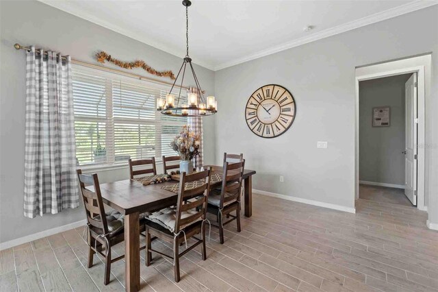 dining room featuring a notable chandelier, ornamental molding, and light hardwood / wood-style flooring