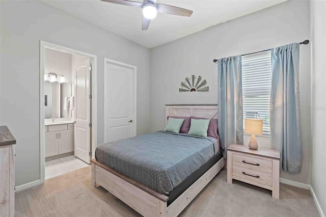 bedroom featuring ensuite bath, light colored carpet, and ceiling fan