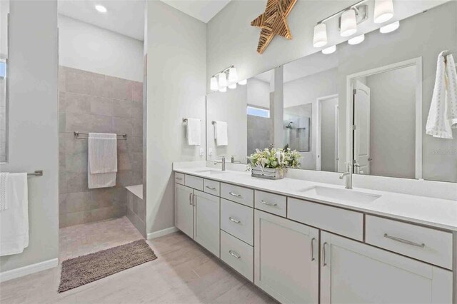 bathroom with tiled shower and vanity