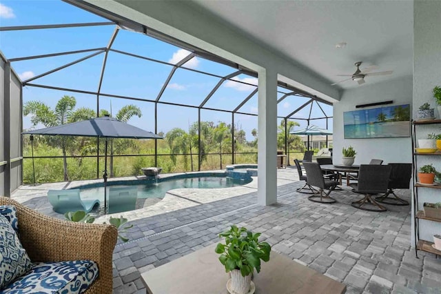 view of pool featuring glass enclosure, ceiling fan, an in ground hot tub, and a patio