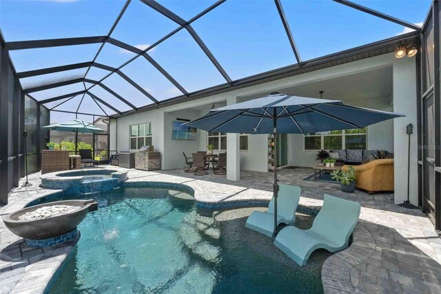 view of swimming pool featuring an in ground hot tub, a patio, and a lanai