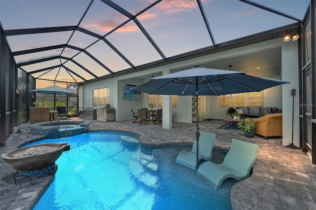 pool at dusk featuring a patio area, a lanai, an in ground hot tub, an outdoor hangout area, and exterior kitchen