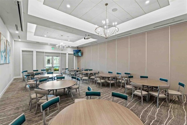 dining area featuring a tray ceiling and an inviting chandelier