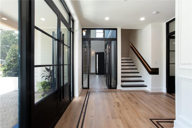 foyer entrance with baseboards, stairway, wood finished floors, expansive windows, and recessed lighting