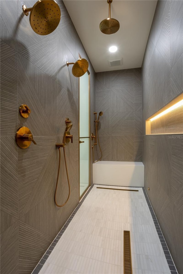 full bathroom featuring visible vents, a walk in shower, and tile walls