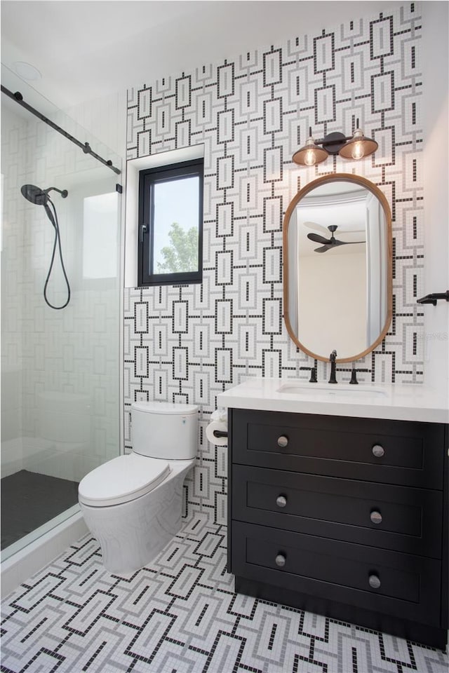 full bathroom featuring tile patterned flooring, toilet, vanity, a ceiling fan, and a shower stall