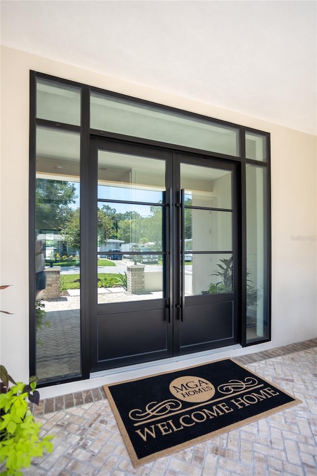 view of exterior entry with stucco siding and french doors