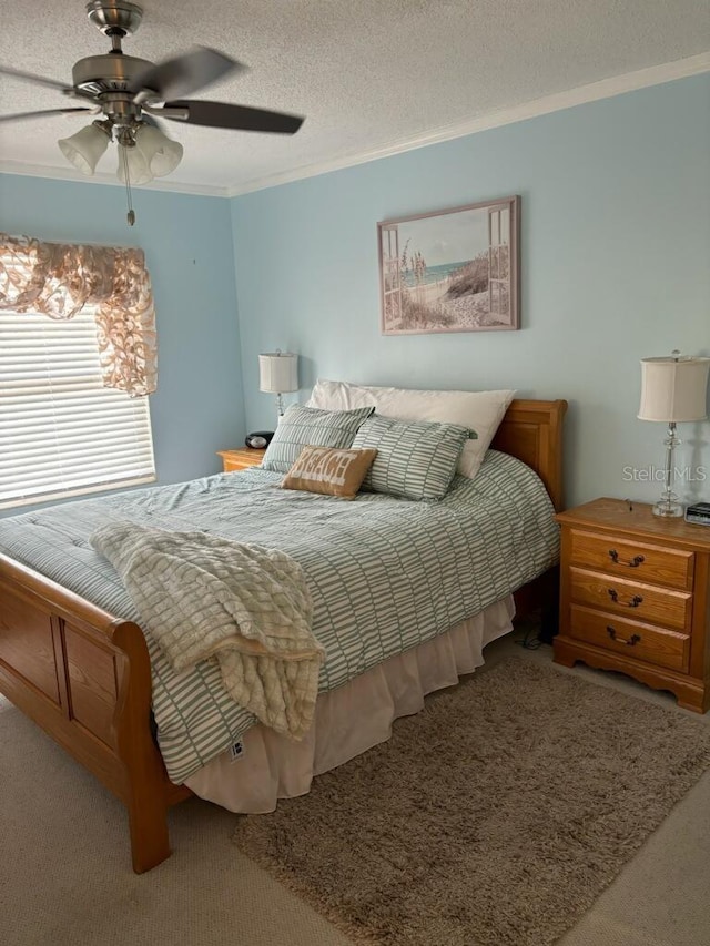 bedroom with ceiling fan, carpet, ornamental molding, and a textured ceiling