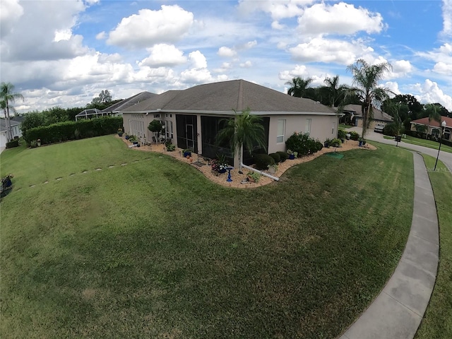 exterior space featuring a sunroom and a lawn