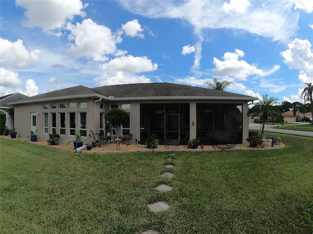 rear view of property with a yard and a sunroom