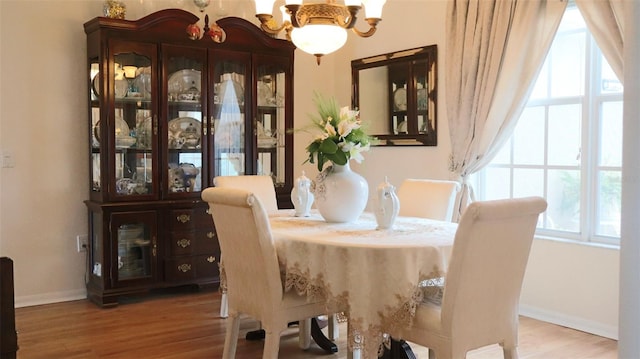 dining room with wood-type flooring, a notable chandelier, and plenty of natural light