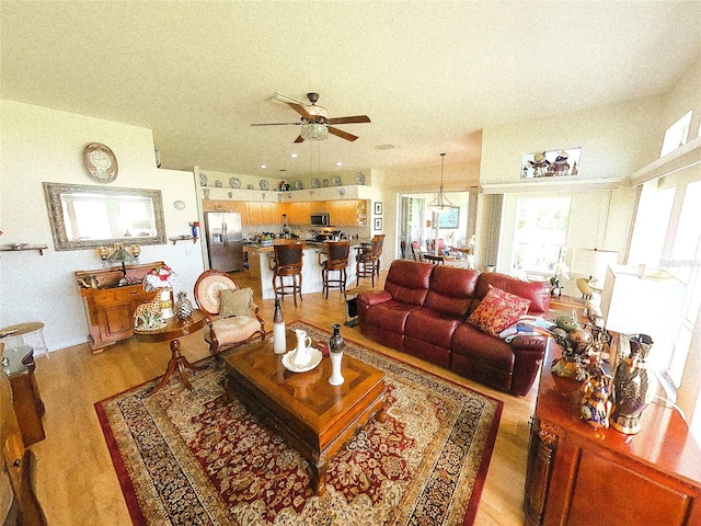 living room with light wood-type flooring and ceiling fan