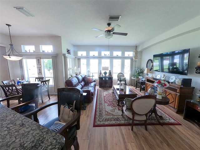 living room featuring ceiling fan, a wealth of natural light, and light hardwood / wood-style flooring