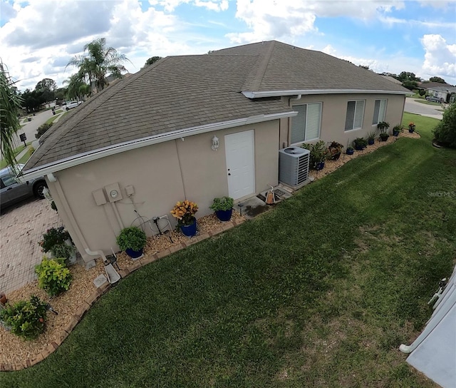 view of side of property featuring central AC unit and a yard