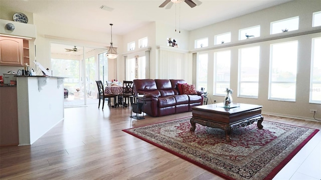 living room with ceiling fan, light hardwood / wood-style flooring, and a wealth of natural light