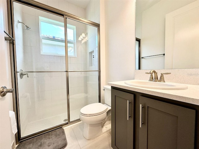 bathroom featuring tile patterned floors, a shower stall, toilet, and vanity