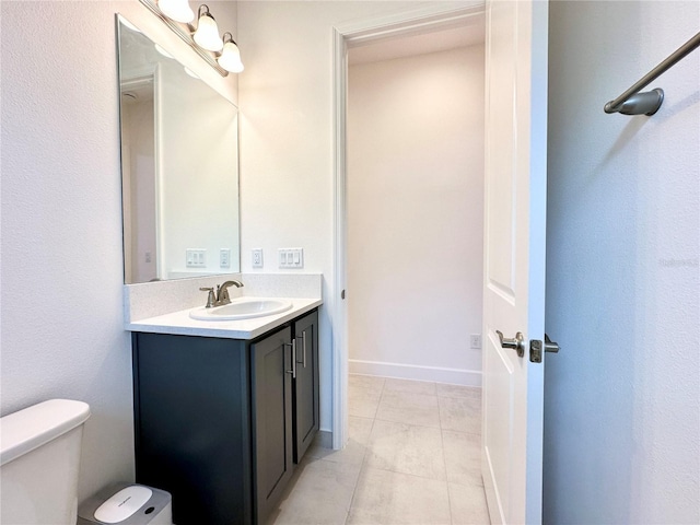 bathroom with baseboards, vanity, toilet, and tile patterned floors