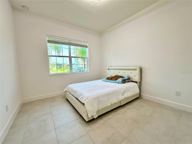 bedroom featuring light tile patterned floors and baseboards