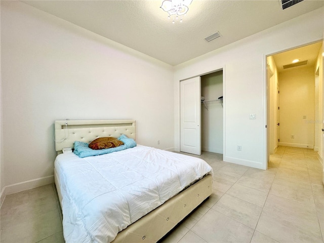 bedroom with a closet, visible vents, baseboards, and light tile patterned floors