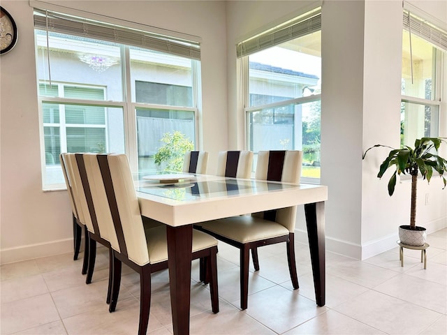 dining space featuring light tile patterned floors and baseboards