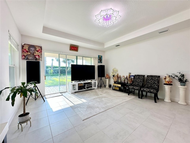 tiled living area featuring visible vents and a raised ceiling